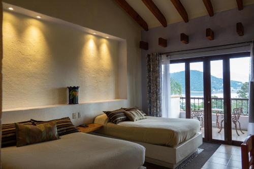 Una habitación de hotel con dos camas y balcón. en Hotel Villas Paraiso, en Valle de Bravo