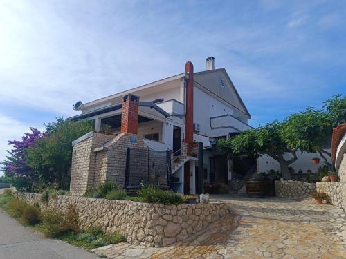 a house with a stone wall next to a street at Studio Apartman Antonia in Rtina