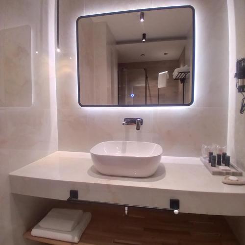 a bathroom with a sink with a large mirror at Ferhadija 31 Old town Sarajevo in Sarajevo
