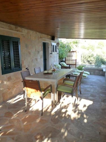 a patio with a table and chairs on a patio at House Bepo in Nerežišće