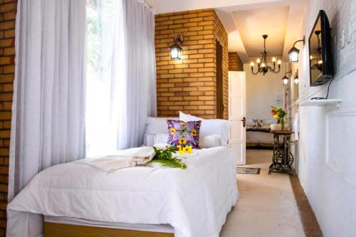 a bedroom with a white bed and a window at Pousada Saruê Praia de Ponta Negra Natal RN in Natal