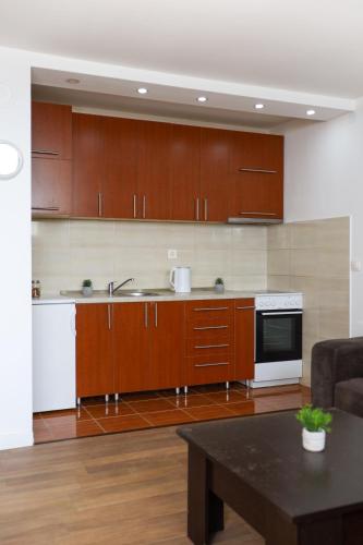 a kitchen with wooden cabinets and a table at Airport Stay Apartments in Surčin