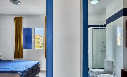 a bedroom with a bed and a shower and a toilet at Casa Branca Beach in Santa Maria