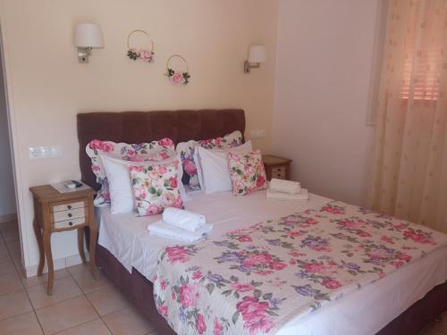 a bedroom with a bed with pink flowers on it at Pension Galazios Kolpos in Patitiri
