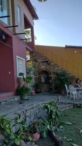 a patio of a house with a table and chairs at Pousada Saruê Praia de Ponta Negra Natal RN in Natal