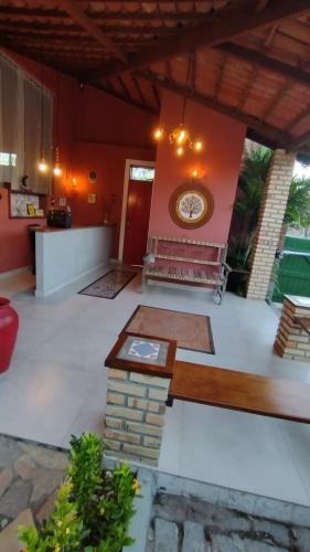 a room with a bench and a clock on a wall at Pousada Saruê Praia de Ponta Negra Natal RN in Natal