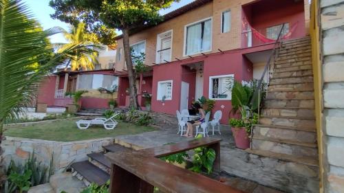 a home with a pink house with a yard at Pousada Saruê Praia de Ponta Negra Natal RN in Natal