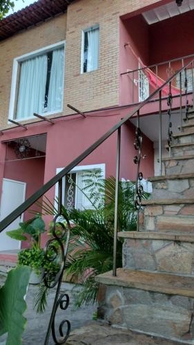 a pink house with stairs in front of it at Pousada Saruê Praia de Ponta Negra Natal RN in Natal
