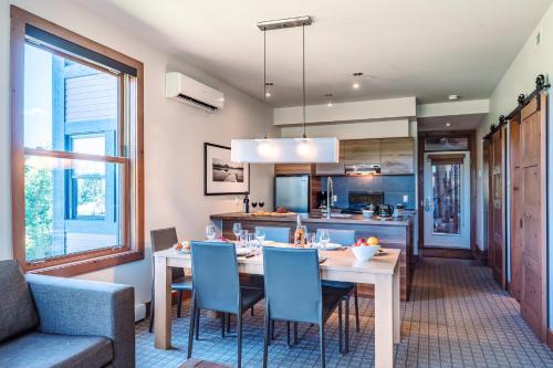a kitchen and dining room with a table and chairs at Lakefront, Mountain View - 2 Bedrooms Resort Suite in Lac-Superieur
