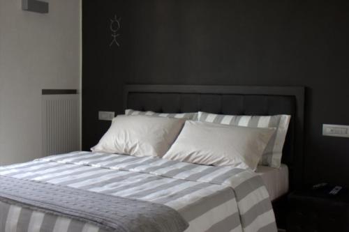 ein Bett mit schwarz-weiß gestreifter Bettwäsche und Kissen in der Unterkunft Home BB Milano in Mailand