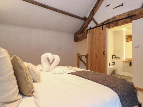 a bedroom with a bed with towels on it at Meadow Syke Byre in Penrith
