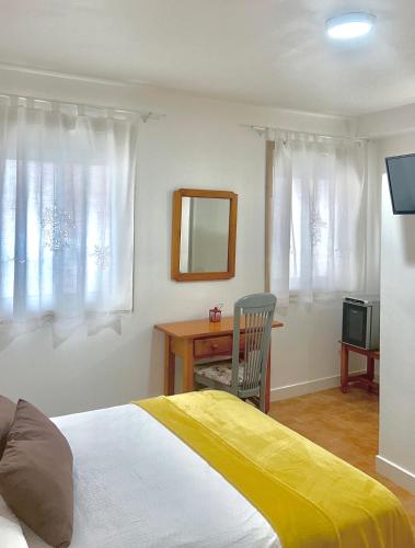 a bedroom with a bed and a desk and a mirror at A Casa de Santos in Combarro