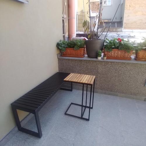 a bench sitting in front of a window with potted plants at Ferhadija 31 Old town Sarajevo in Sarajevo