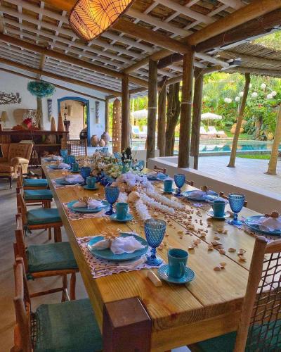 een lange houten tafel met blauwe kopjes en borden bij Hotel Boutique Perainda in Trancoso