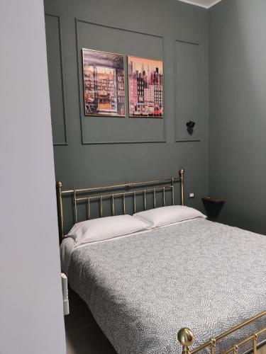 a bedroom with a bed with two pictures on the wall at Bologna Travel Suite in Bologna