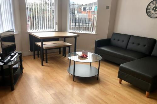 a living room with a couch and a table at Cliftonville Apartments in Belfast