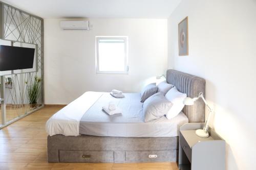 a bedroom with a bed and a television in it at Airport Stay Apartments in Surčin