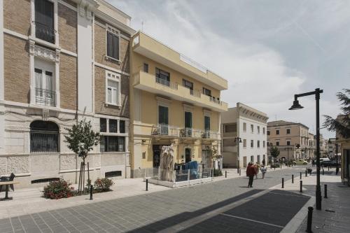 a building with a statue in the middle of a street at Dimora Don Minzoni in Matera