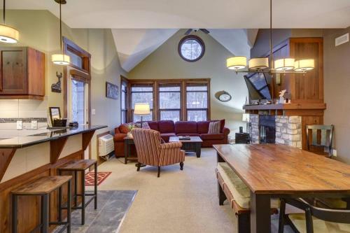 a kitchen and living room with a couch and a table at Les Eaux Tremblant Classic Chalet Pool & Jacuzzi in Mont-Tremblant