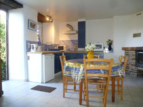 une cuisine avec une table et des chaises dans une cuisine dans l'établissement Pélégrine, à Gabriac