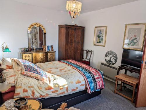 ヘルムズデールにあるSelkie House Song of the Seaのベッド、テレビ、テーブルのある寝室