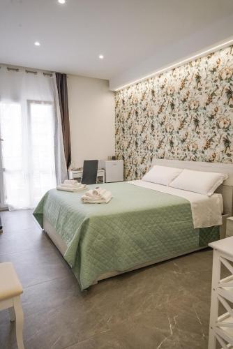 a bedroom with a large bed with a green blanket at La Peonia B&B in Ragusa