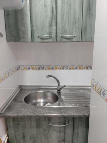 a stainless steel sink in a kitchen with a mirror at M&Mcies in Baiona