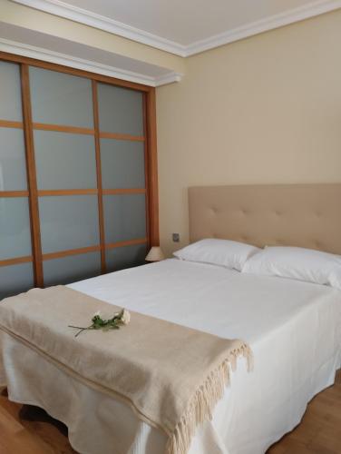 a bedroom with a large white bed with a table at M&Mcies in Baiona