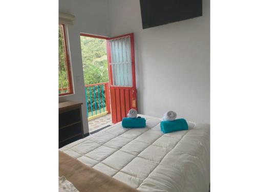 two babies sitting on a bed in a room with a window at Hotel Cafetero Valparaíso in La Vega