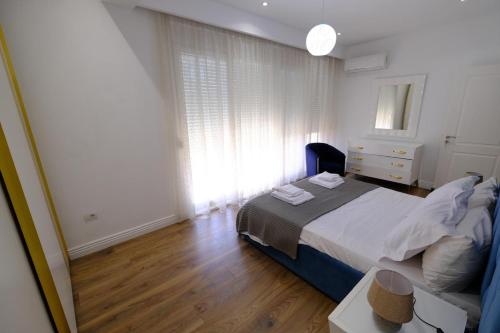 a bedroom with a bed and a dresser and a window at Bala apartment in Tirana