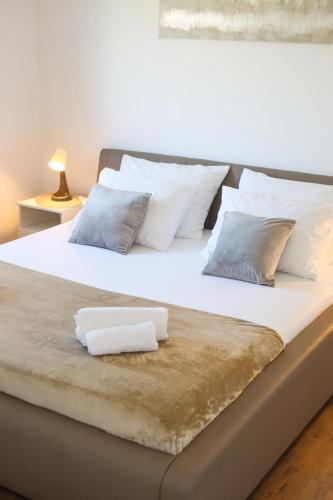 a large bed with two white towels on it at Airport Stay Apartments in Surčin