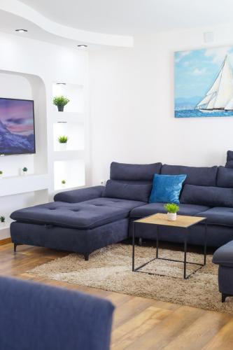 a living room with a blue couch and a table at Airport Stay Apartments in Surčin