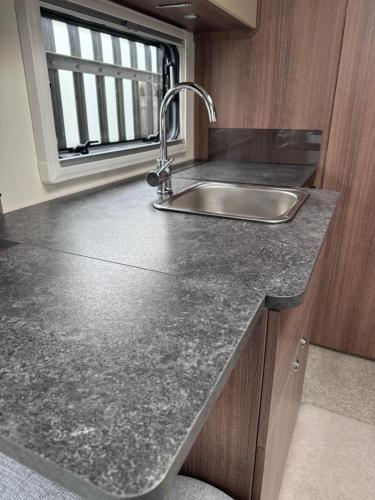 a kitchen counter with a sink and a window at Tayys Inn Luxury Camp in Birmingham