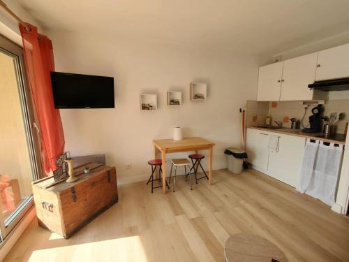 une cuisine avec une table et une petite table avec des chaises dans l'établissement Saint-Mandrier-sur-Mer Rsd Les comètes, à Saint-Mandrier-sur-Mer