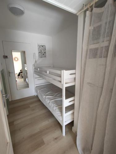- une chambre blanche avec des lits superposés et un miroir dans l'établissement Saint-Mandrier-sur-Mer Rsd Les comètes, à Saint-Mandrier-sur-Mer