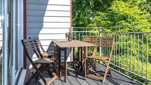 ein Holztisch und zwei Stühle auf einer Veranda in der Unterkunft Ta Mill Cottages & Lodges - Meadowview Chalet 4 in Launceston
