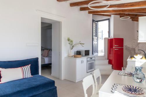 a living room with a blue couch and a red refrigerator at Captain Hook in Hydra