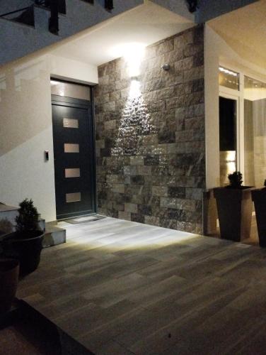 a lobby with a black door and a stone wall at Villa Twins Dojran in Nov Dojran