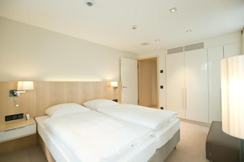 a white bedroom with a large white bed in it at Seminar- & Tagungshotel Große Ledder in Wermelskirchen