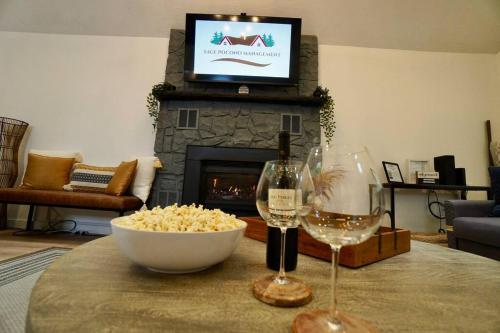 a table with a bowl of popcorn and two wine glasses at Poconos Oasis with Game Room in Pocono Summit