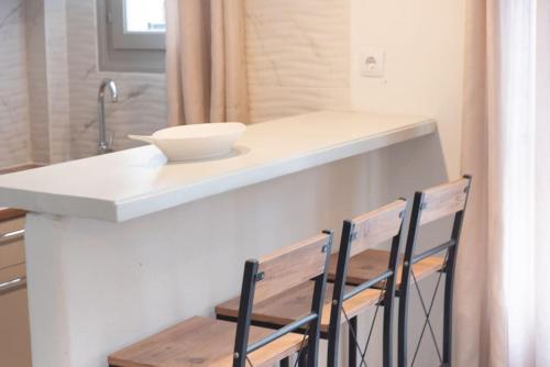 a kitchen with two chairs and a counter with a bowl on it at SWELL S5 new studio in Naousa in Naousa
