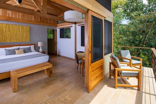 a bedroom with a bed and a balcony at El Remanso Rainforest Lodge in Puerto Jiménez