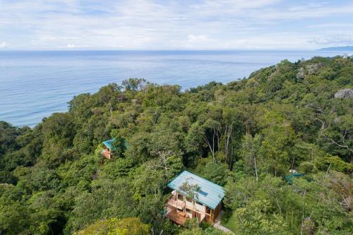 an aerial view of a house on a hill next to the ocean at El Remanso Rainforest Lodge in Puerto Jiménez