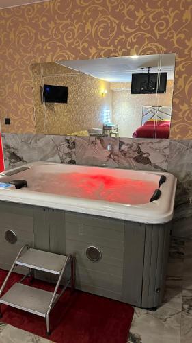 une salle de bain avec une grande baignoire et un miroir dans l'établissement Le Palais du Khalif, à Fabrègues