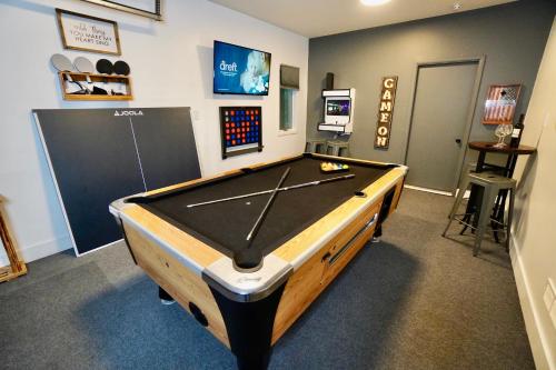 a ping pong table in a room with a pool at Poconos Oasis with Game Room in Pocono Summit
