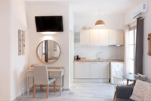 a white kitchen with a table and a mirror at SWELL S6 new studio in Naousa in Naousa