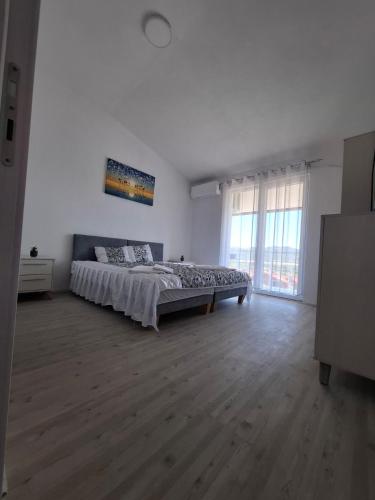 a bedroom with a large bed in a white room at Chorev Apartments in Valandovo