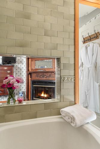 a bath tub with a fireplace in a bathroom at Inn at Ellis River in Jackson