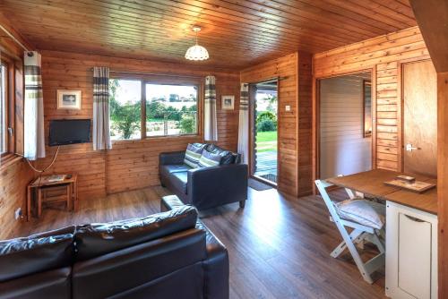 ein Wohnzimmer mit Sofa und Tisch in der Unterkunft Ta Mill Cottages & Lodges - Brookview Lodge 2 in Launceston