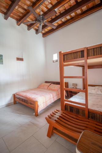 a bedroom with two bunk beds and a bench at Casa Castilla in Santa Marta